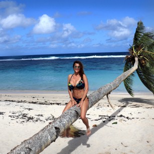 A Beautiful woman in bikini siting on a coconut tree on a paradise beach in Samoa, by Omnimundi