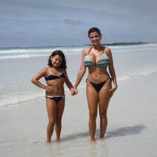Two beatiful tourists in bikini on a pristine beach in the Galapagos Islands, by Omnimundi